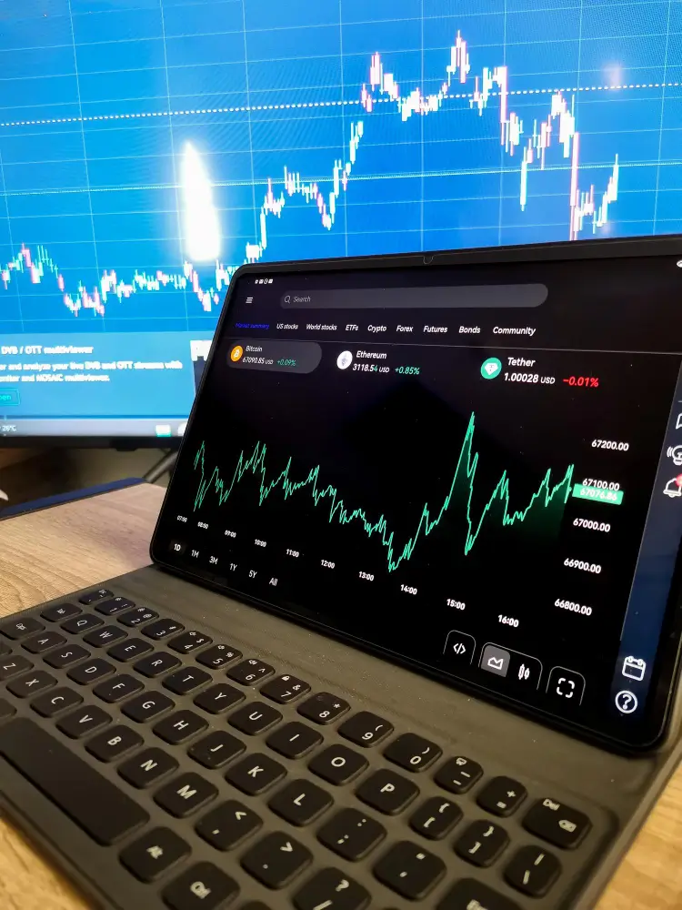 Digital stock market charts displayed on laptop and screen, representing career-focused learning in Diploma in Accounting and Finance.